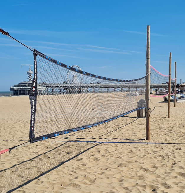 beachvolley-en-soccer Beachvolleybalnet op het strand voor beachclub Solbeach met De Pier op de achtergrond.