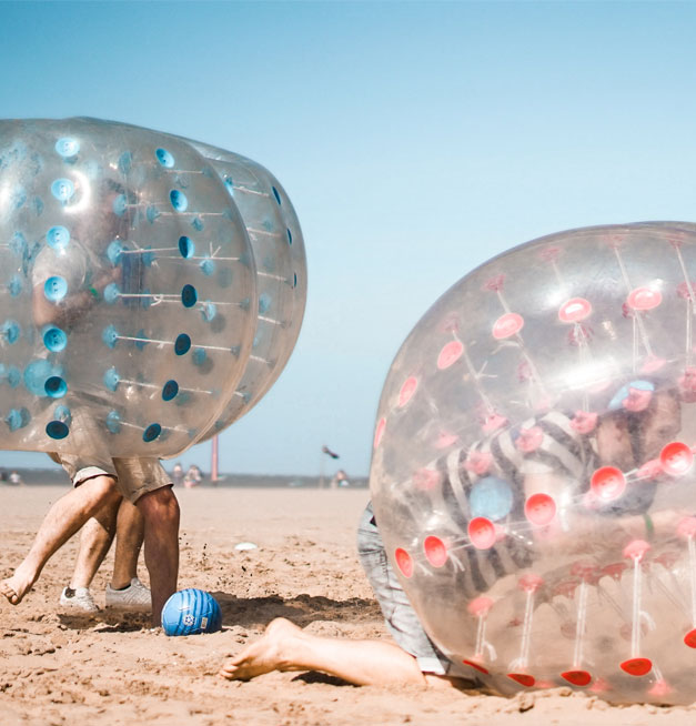 bubblevoetbal Grote opblaasbare bumperballen op het strand voor een actieve sessie bubble voetbal bij Solbeach.