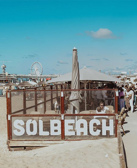 Overzicht van het terras van beachclub Solbeach met De Pier van Scheveningen op de achtergrond.