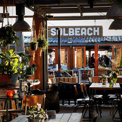 De houten buitenbar en het terras van strandtent Solbeach Scheveningen.