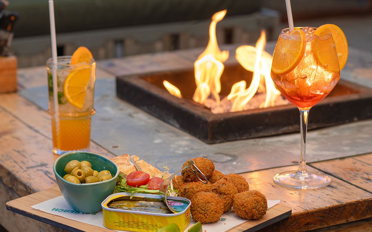 borrelbites Sfeervolle terrashaard met tapas en borrelbites op tafel bij beachclub Solbeach Scheveningen.