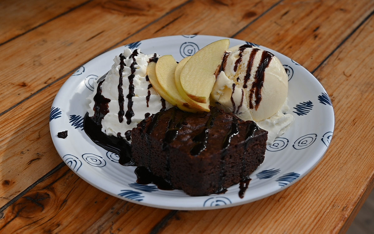 Huisgemaakt chocoladetoetje met ijs en fruit geserveerd bij strandtent Solbeach.