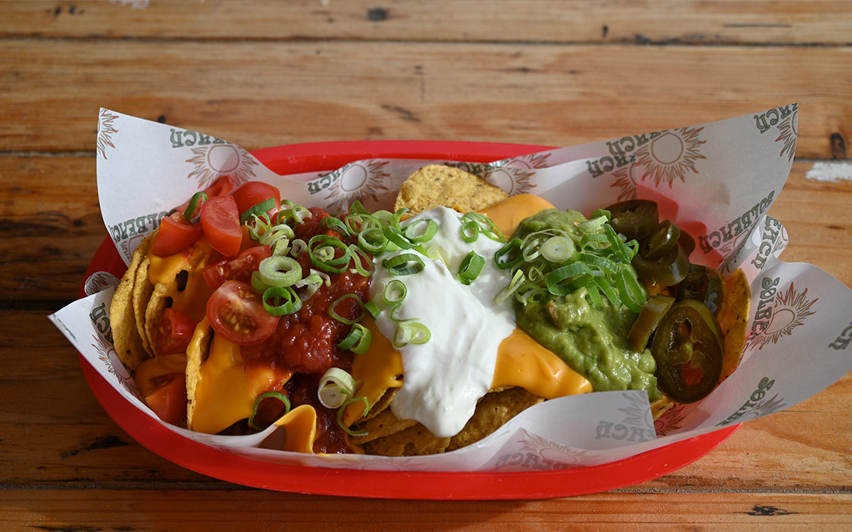 Rijkelijk belegde loaded fries met toppings op het terras van Solbeach Scheveningen.