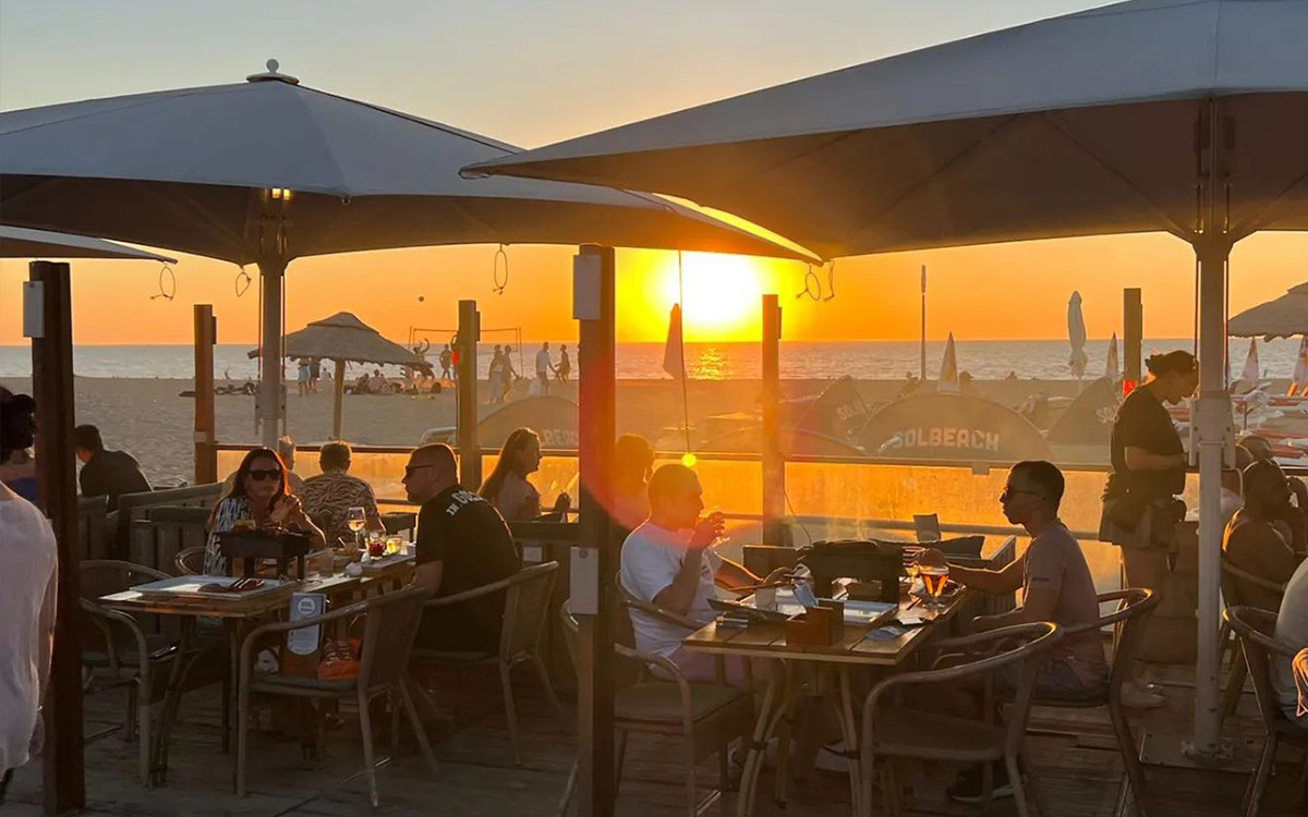 Dineren aan zee bij zonsondergang op het sfeervolle terras van beachclub Solbeach Scheveningen.