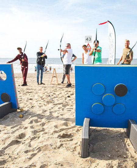 Archery tag arena op het strand van Scheveningen met targets en bogen voor bedrijfsuitjes.