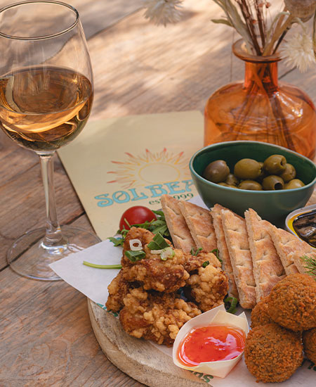 Glas wijn en borrelhapjes tijdens een zakelijk diner bij beachclub Solbeach aan zee.