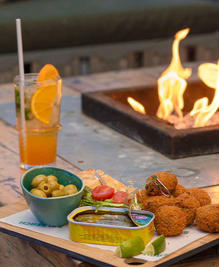 Kleurrijke cocktails en tapas bij de terrashaard van strandtent Solbeach Scheveningen.