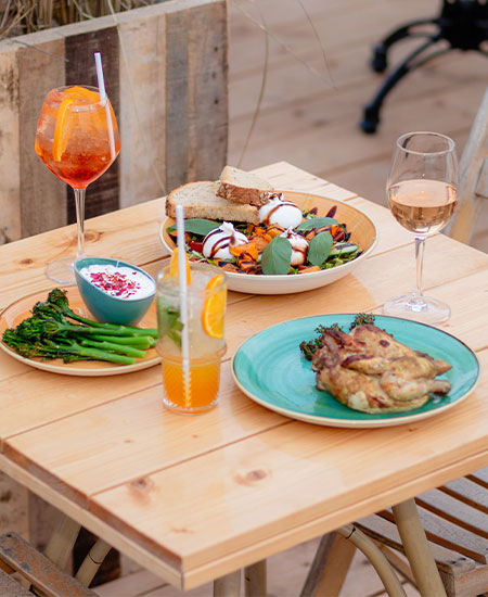 Zomerse drankjes en dinergerechten op het terras van beachclub Solbeach tijdens een bedrijfsuitje.