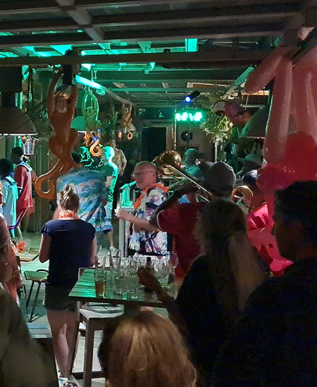 Kleurrijke strandparty met ballondecoratie en dansende gasten bij beachclub Solbeach Scheveningen.
