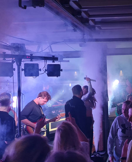 Live band en DJ op het podium met spectaculair licht tijdens een feestavond bij Solbeach.