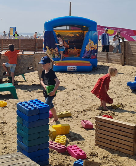Groot springkussen op het zandstrand van Scheveningen tijdens een zomerevent bij Solbeach.