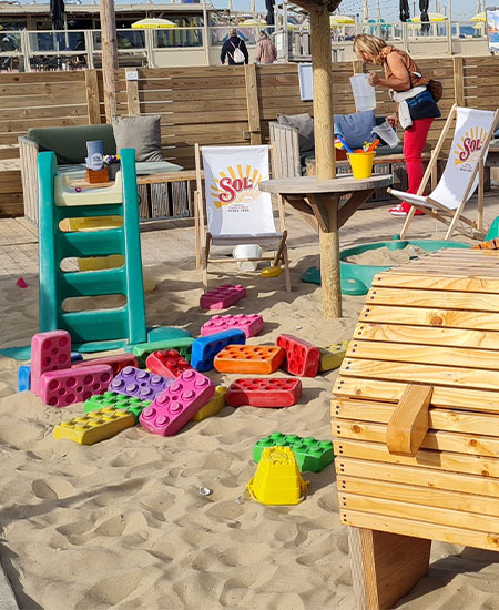 Kleurrijke speelhoek en bouwblokken op het terras van strandtent Solbeach Scheveningen.