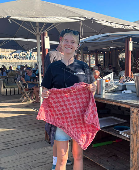 Enthousiaste medewerker klaar voor de service bij beachclub Solbeach Scheveningen.
