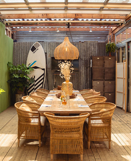 Stijlvolle vergaderruimte met surfboard en houten vergadertafel bij strandtent Solbeach.