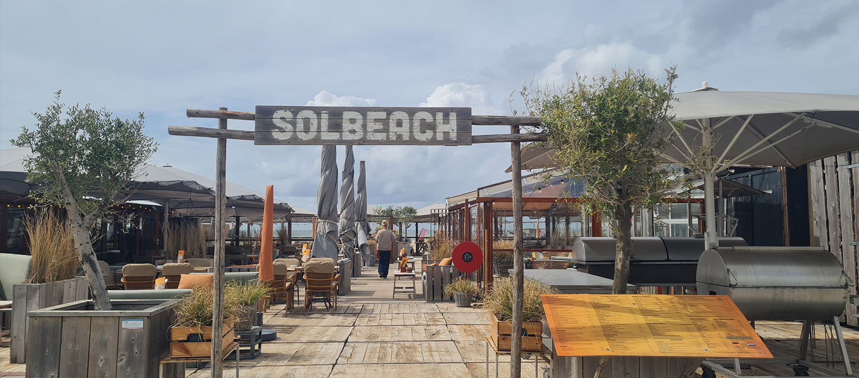 De kenmerkende houten entreeboog van strandtent Solbeach op het strand van Scheveningen.
