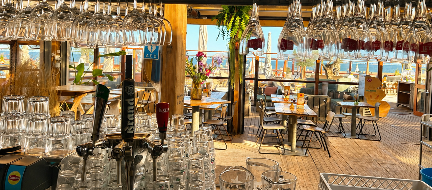 Warm verlicht interieur van het strandpaviljoen bij beachclub Solbeach Scheveningen.