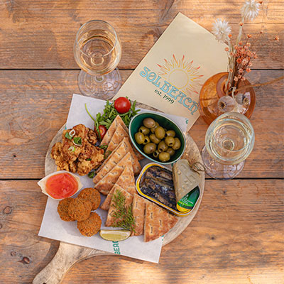 Wijnglazen en borrelbites op tafel tijdens een gezellige netwerkborrel bij beachclub Solbeach.