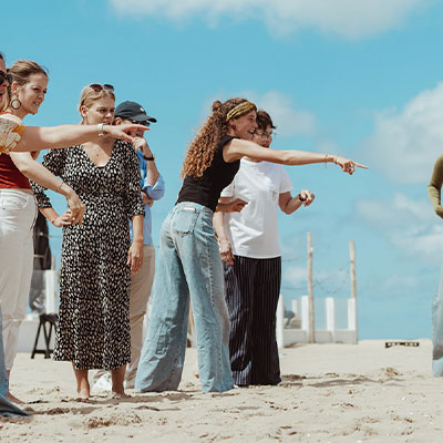 Collega's genieten van het uitzicht over zee tijdens een bedrijfsuitje bij strandtent Solbeach.