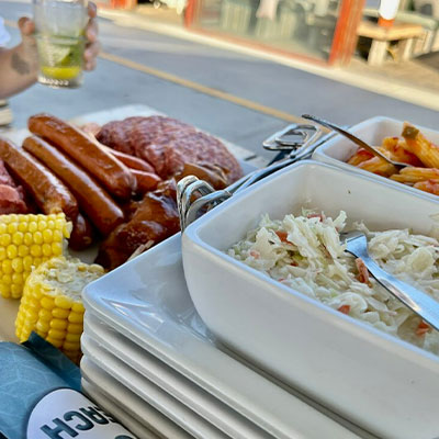 Barbecuebuffet met salade, maïs en diverse soorten vlees bij beachclub Solbeach Scheveningen.