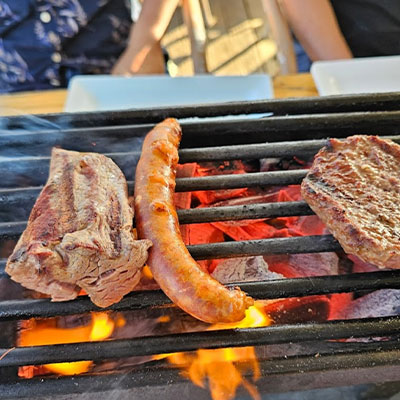 Vlees en worsten roosteren op de barbecue tijdens een zakelijk BBQ-bedrijfsuitje bij Solbeach.