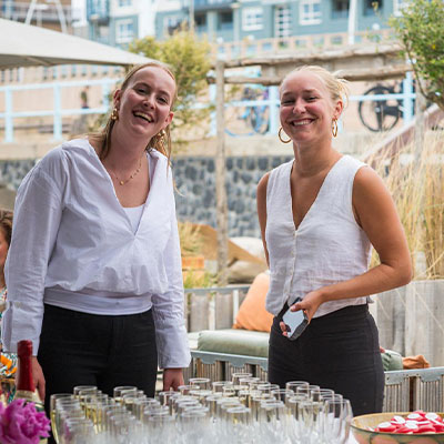 Gastvrije horecamedewerkers verwelkomen gasten voor een feest bij beachclub Solbeach Scheveningen.