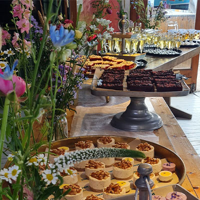 Rijk gevuld dessertbuffet met taartjes en zoetigheden voor een feest bij beachclub Solbeach.
