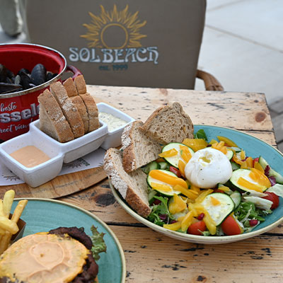 Gezonde lunchsalade en verse broodjes op tafel bij strandtent Solbeach Scheveningen.