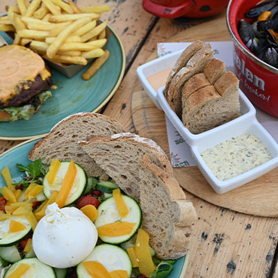 Luxe burger met knapperige friet en vers brood van de dinerkaart bij strandtent Solbeach.