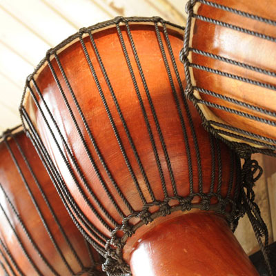 Traditionele djembé trommels gereed voor een percussieworkshop bij strandtent Solbeach.