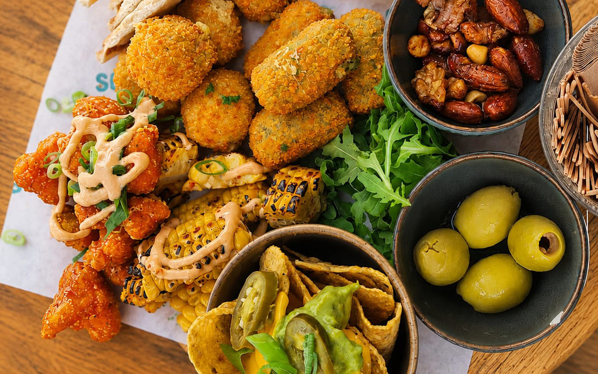 Luxe borrelhapjes en warme snacks op tafel bij beachclub Solbeach Scheveningen.