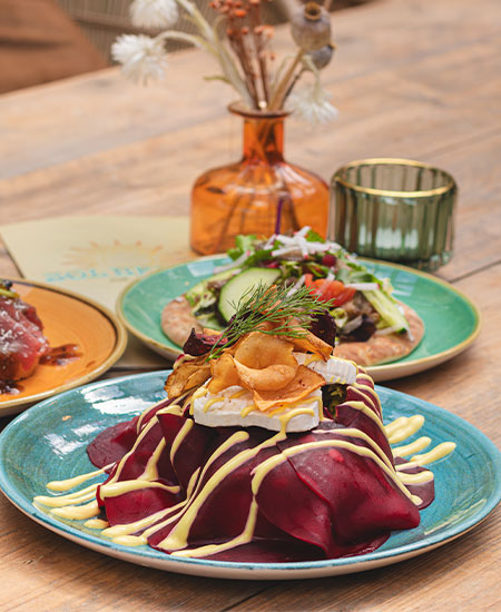 Zomers lunchgerecht op een sfeervol gedekte terrastafel bij beachclub Solbeach.