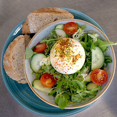 Frisse lunchsalade met burrata en knapperig brood op het terras van strandtent Solbeach.
