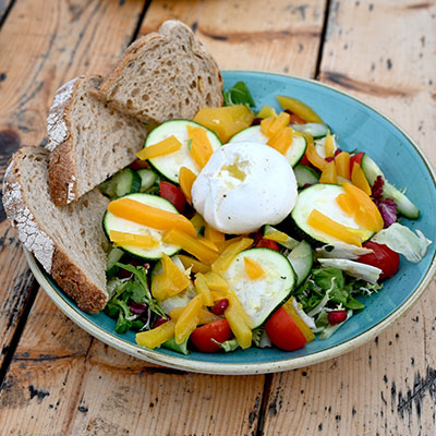 Gezonde saladebowl met avocado, ei en brood tijdens een zakelijke lunch bij Solbeach.