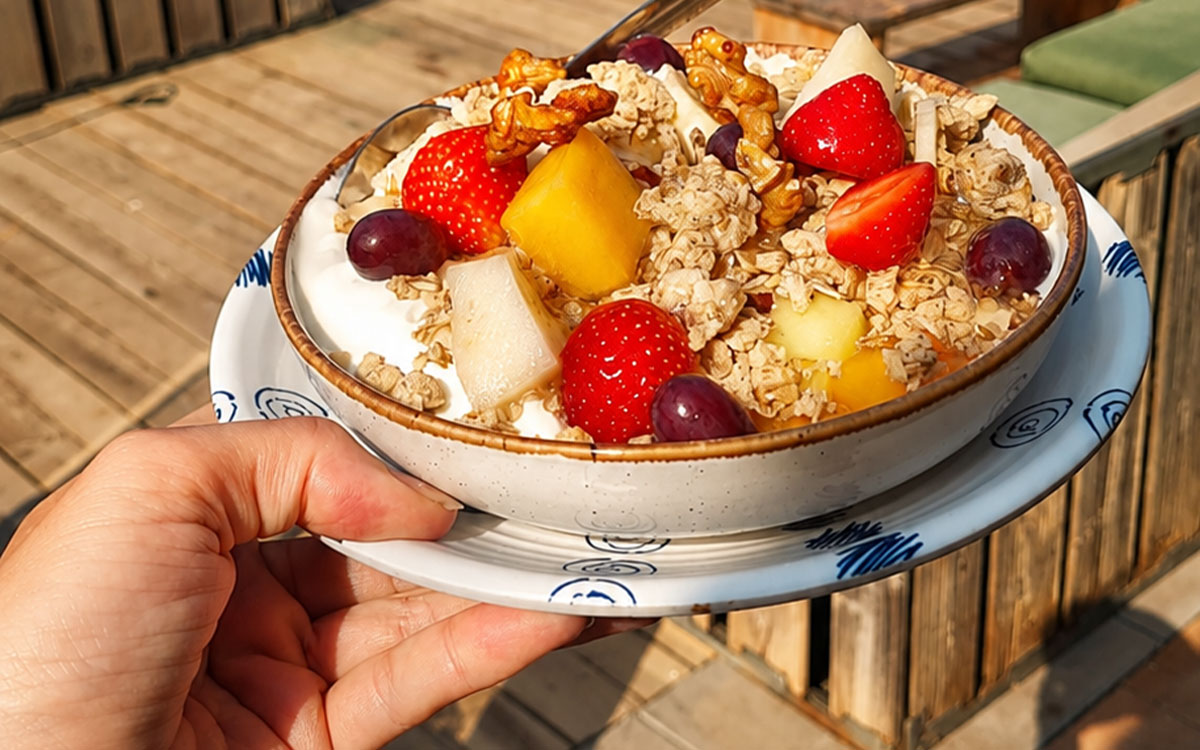 Frisse ontbijtbowl met yoghurt, granola en rood fruit geserveerd bij strandtent Solbeach.