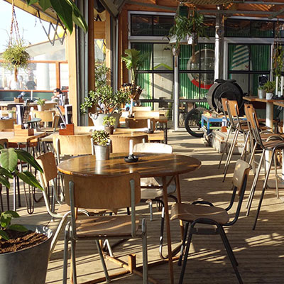 Lichte en moderne inrichting van beachclub Solbeach Scheveningen met uitzicht op zee.