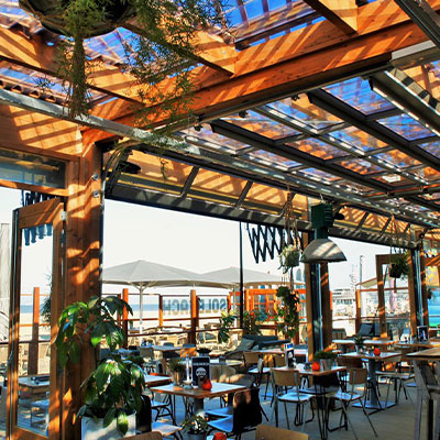Houten overkapping van beachclub Solbeach Scheveningen voor beschut buiten borrelen.