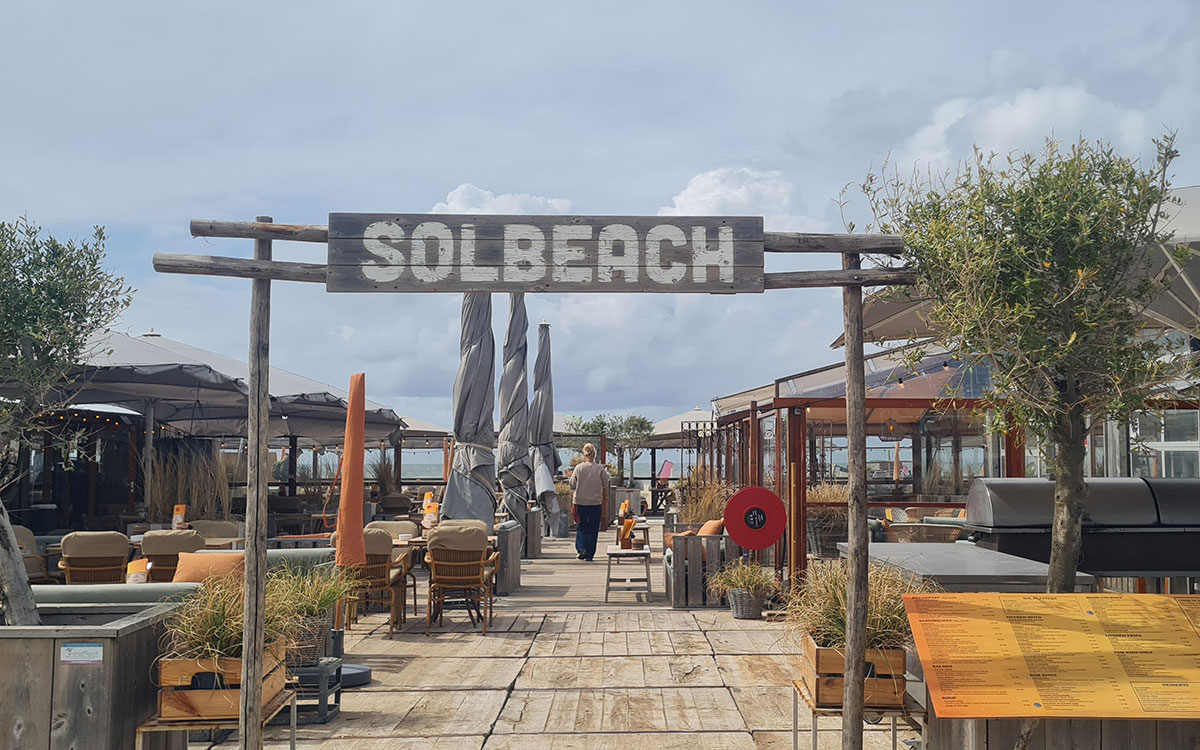 strandfeestdetail Houten welkomstboog van beachclub Solbeach op het strand van Scheveningen voor een strandfeest.