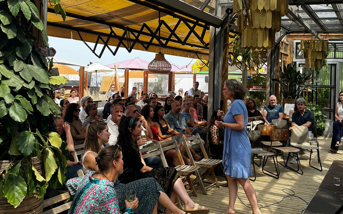 Gezelschap bijeen voor een zakelijke presentatie op het terras van beachclub Solbeach.