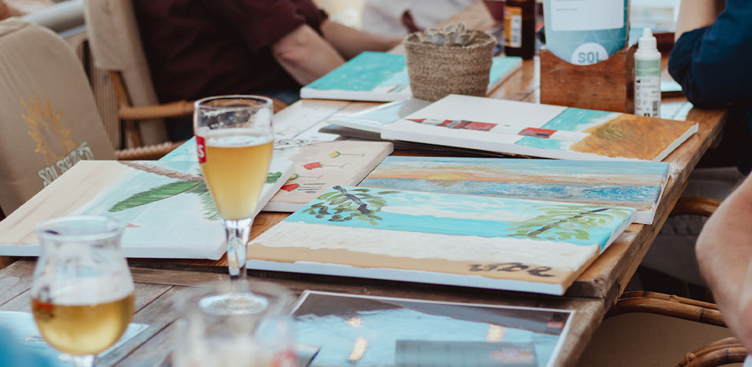 Schilderspullen en een drankje klaar voor een creatieve workshop bij strandtent Solbeach.