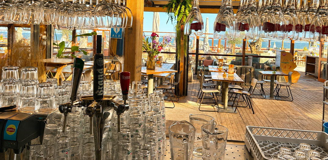 waaromhighwine1 Sfeervol interieur van strandtent Solbeach met wijnglazen klaar voor een zakelijke proeverij.